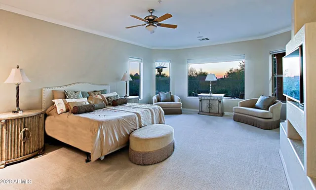 a spacious bedroom with a bed a couch and a chandelier