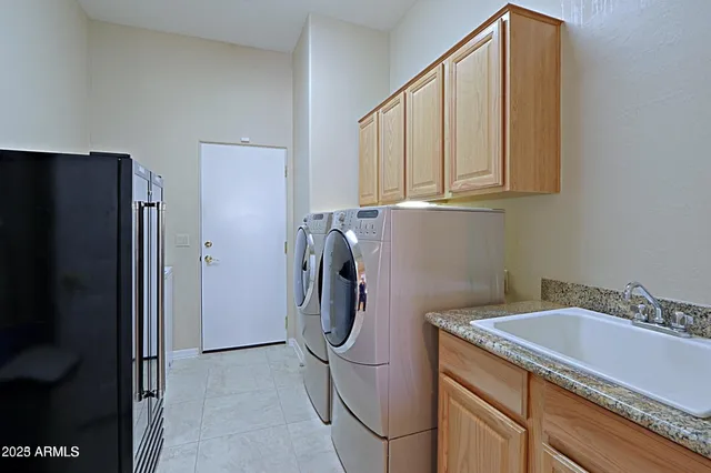 a utility room with granite countertop a sink a washer and dryer