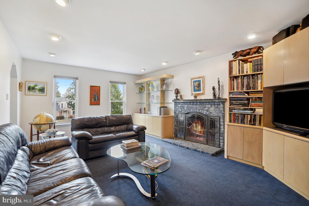 7802 Ivymount Terrace Potomac, MD 20854 - Photo 12 of 51 a living room with furniture a fireplace and a flat screen tv