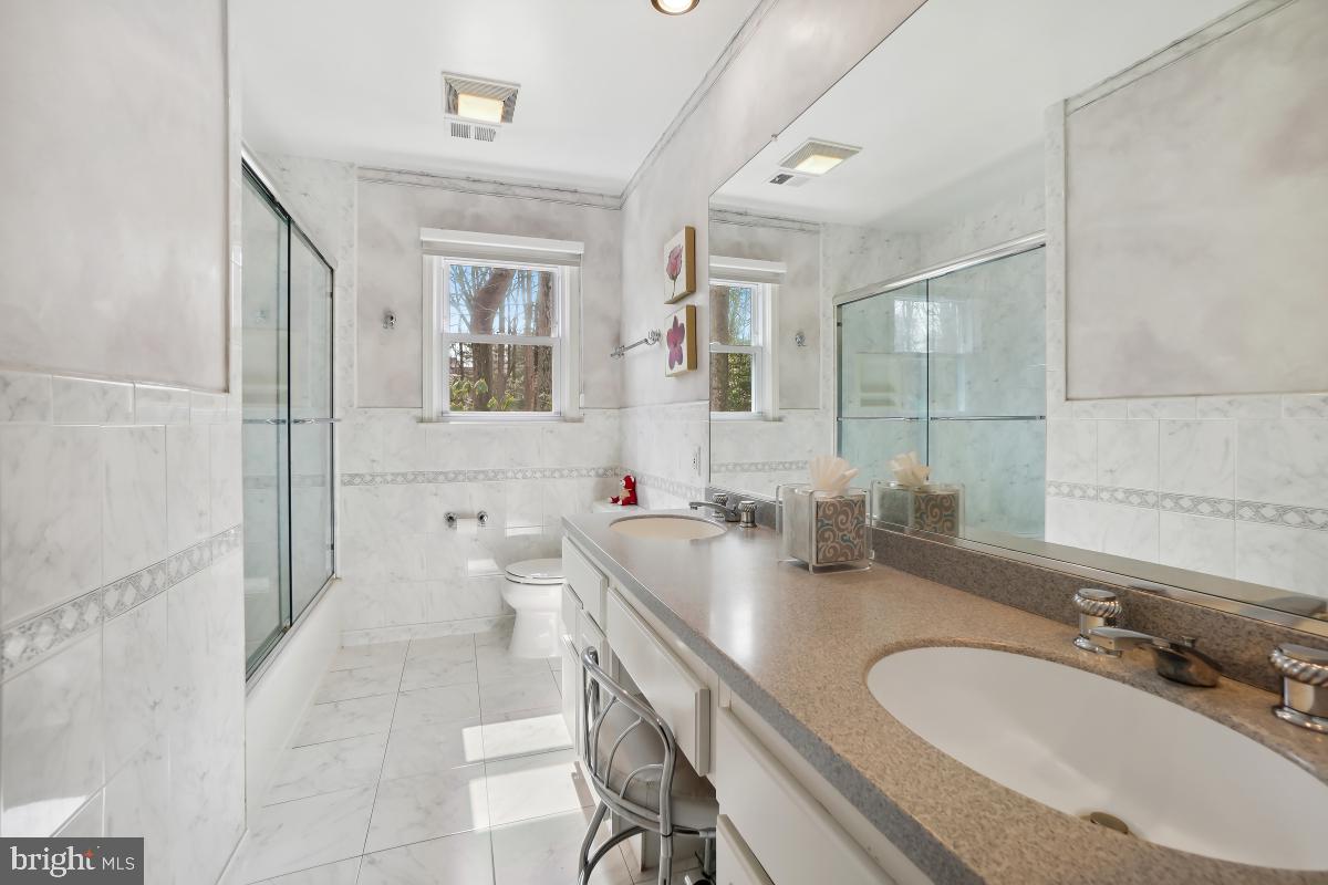 7802 Ivymount Terrace Potomac, MD 20854 - Photo 22 of 51 a bathroom with double vanity sinks a mirror and a shower