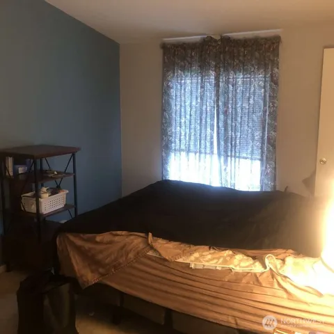 a bedroom with a bed window and mirror