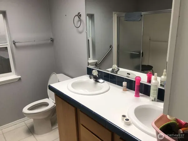 a bathroom with a sink vanity mirror and toilet