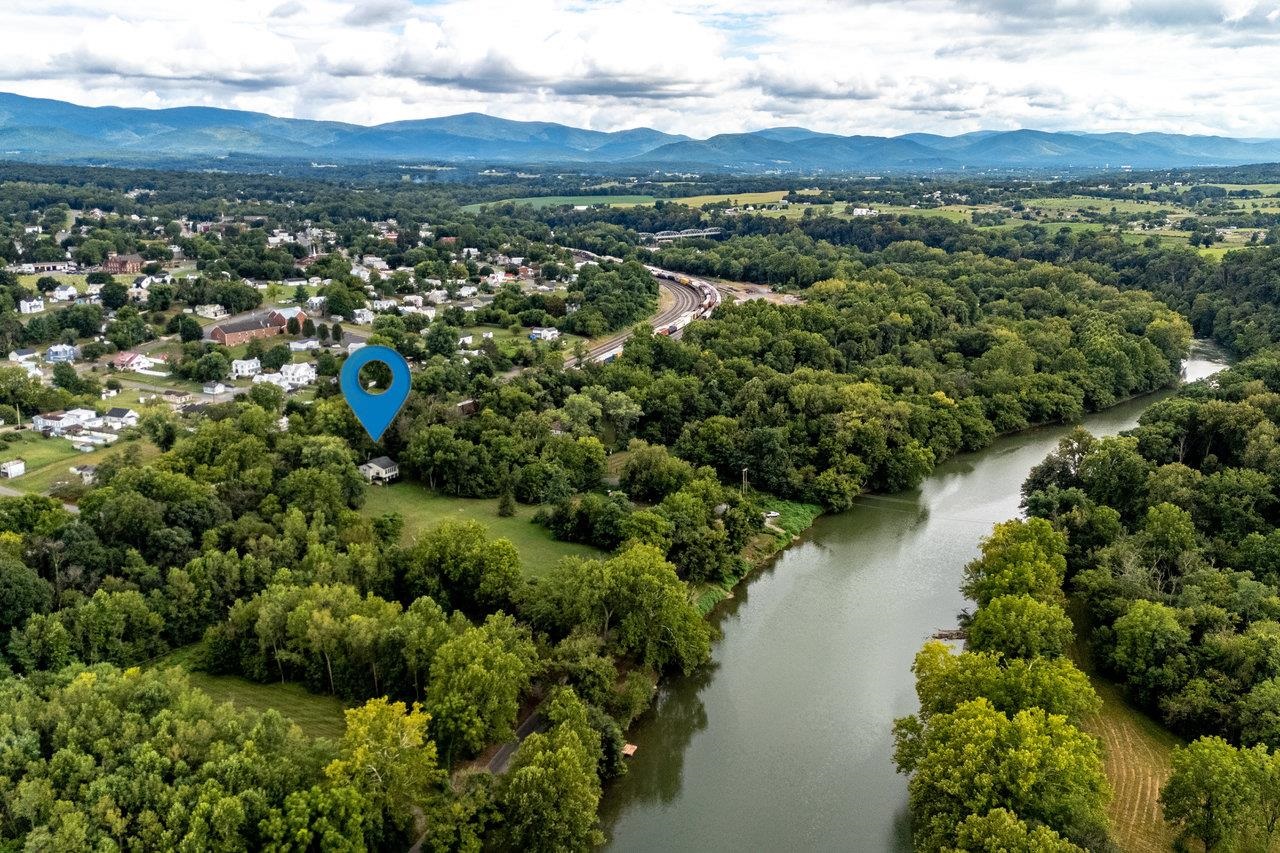 an aerial view of green landscape with trees houses and mountain view