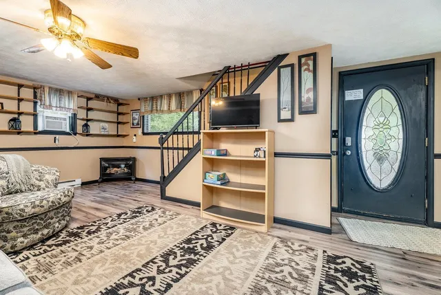 a view of a hallway with bed and wooden floor