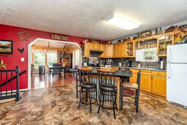 a dining area with stainless steel appliances kitchen island granite countertop a dining table chairs and a large window