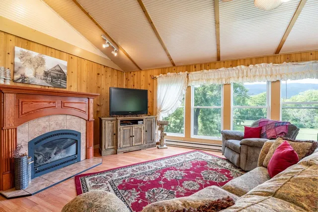 a living room with furniture a flat screen tv and a fireplace