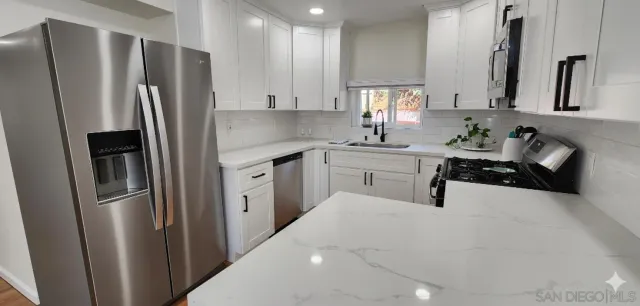 a kitchen with stainless steel appliances a refrigerator sink and cabinets