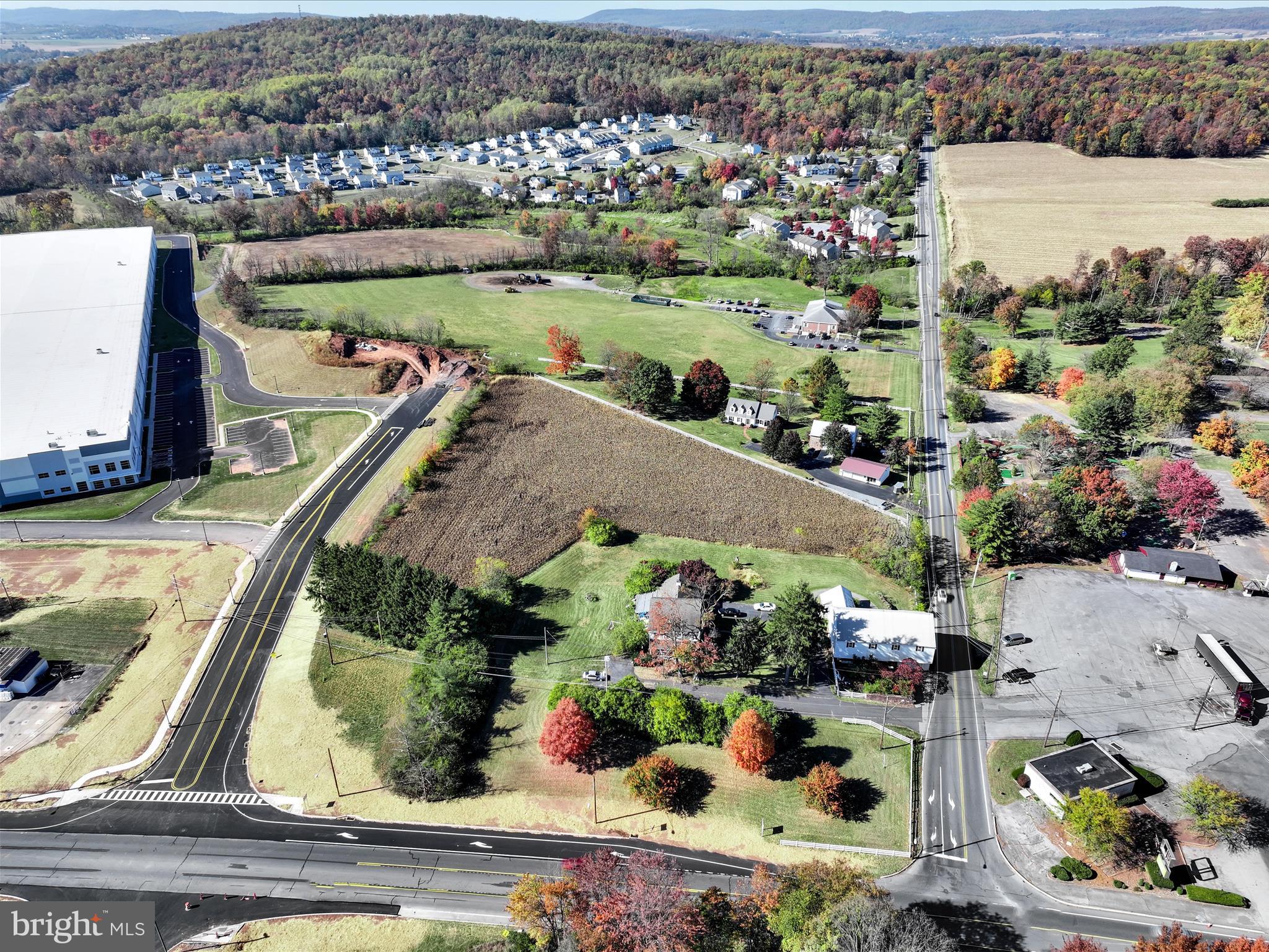 an aerial view of a house with a garden and lake view