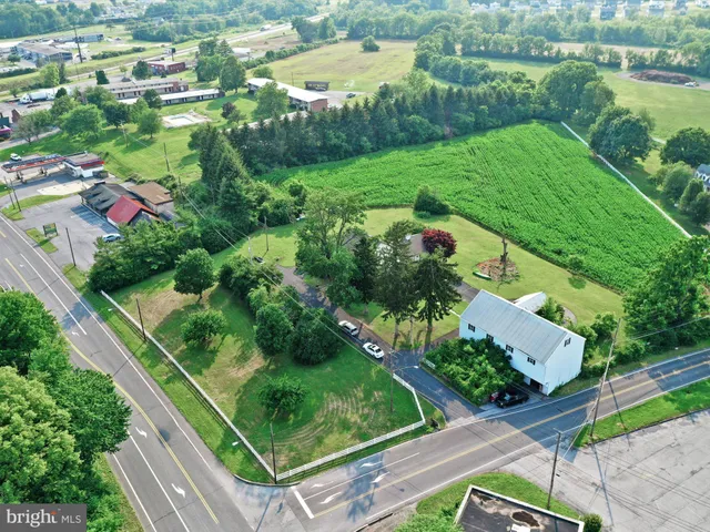 an aerial view of green landscape with trees houses and wooden fence