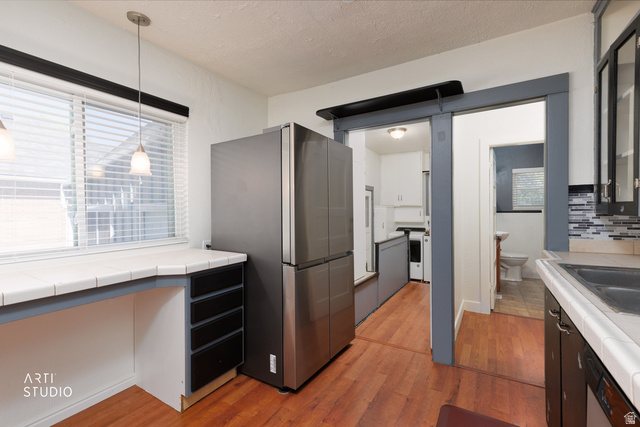 146 West 200 N Street Springville, UT 84663 - Photo 12 of 29 Kitchen space featuring wood-finish flooring, a stainless steel refrigerator, and a tiled countertop with dark cabinetry