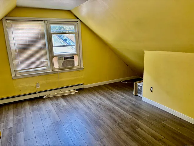 a view of a room with wooden floor and a window