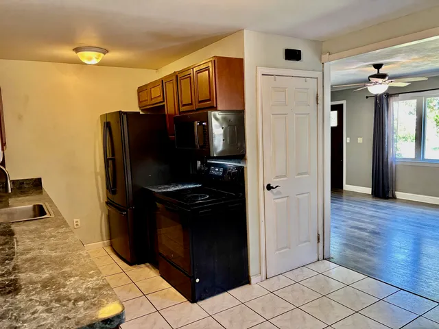 a kitchen with stainless steel appliances granite countertop a refrigerator and a stove top oven