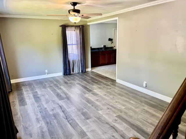 a view of a livingroom with a furniture ceiling fan and window