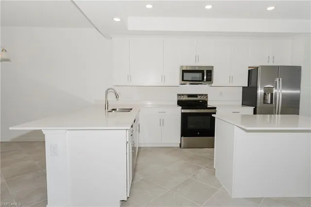 a kitchen with a refrigerator a stove and a sink