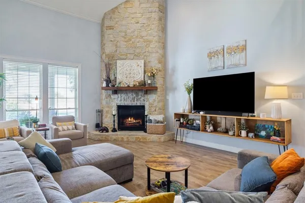 a living room with furniture a flat screen tv and a fireplace