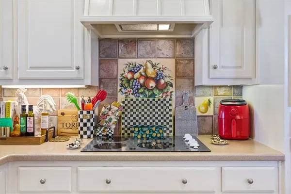 a kitchen with white cabinets and sink