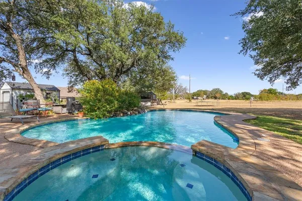 a view of pool with yard and green space