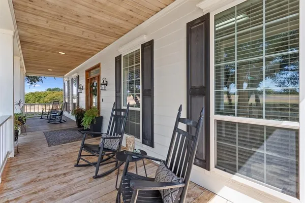 a porch area with table and chairs