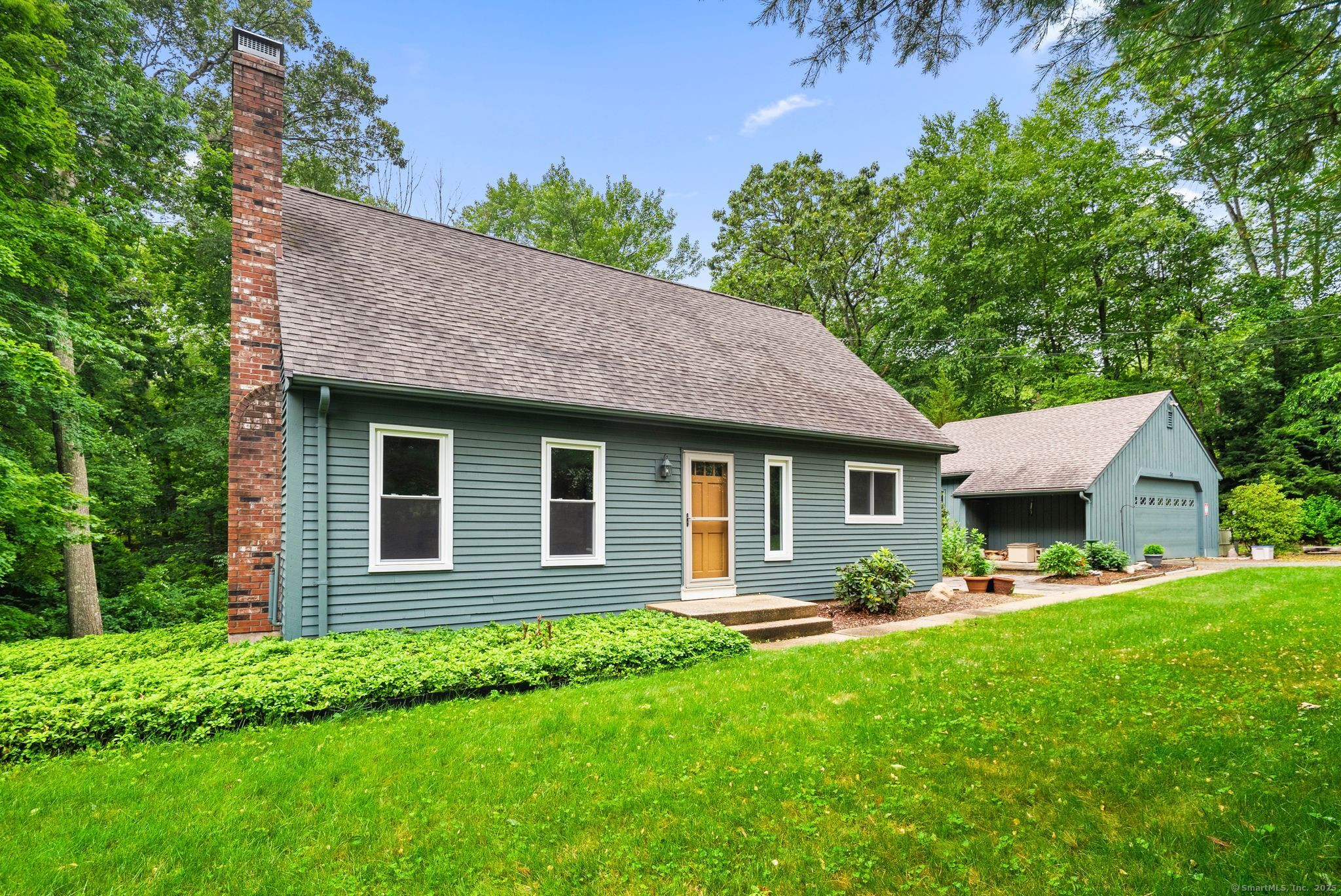 a front view of a house with a yard and green space