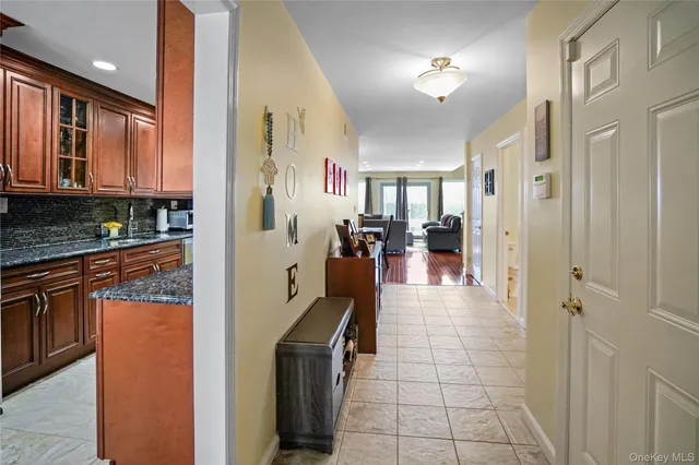 a hallway with stainless steel appliances granite countertop a refrigerator and a sink
