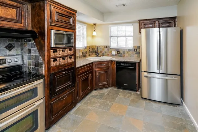 a kitchen with stainless steel appliances granite countertop a stove and a microwave