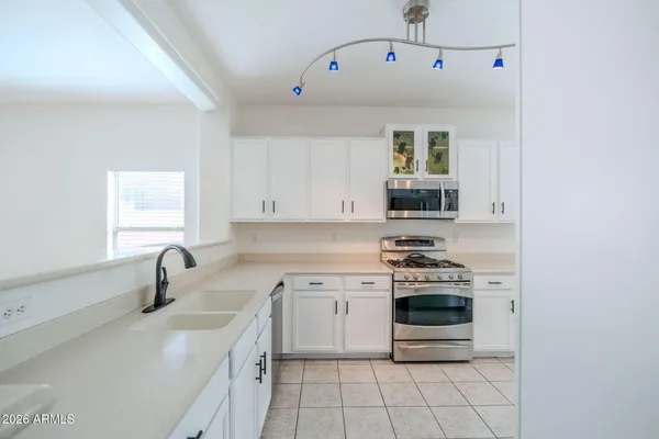 a kitchen with stainless steel appliances granite countertop a sink stove and cabinets