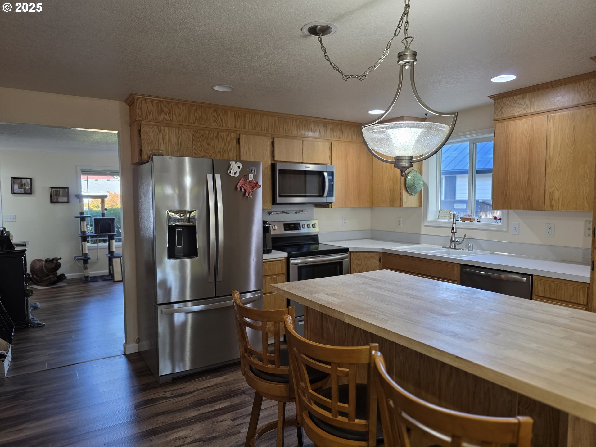 413 Southeast 8th Street Battle Ground, WA 98604 - Photo 15 of 18 a kitchen with kitchen island a counter space a refrigerator and a chandelier
