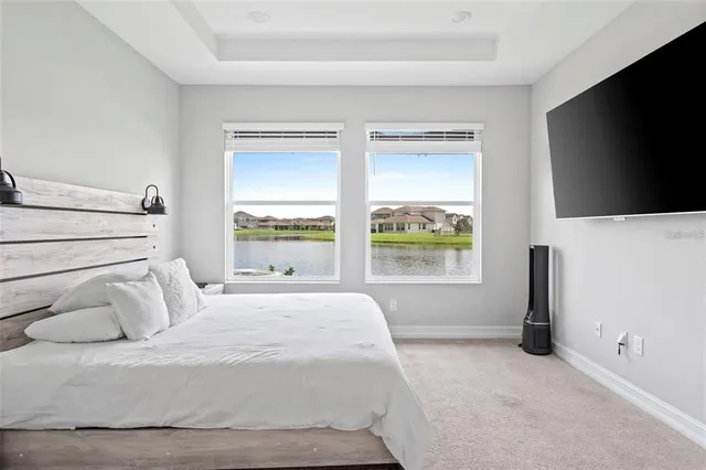 a bedroom with a large bed and a flat tv screen on dresser