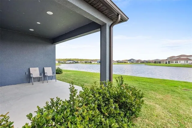 a view of a chair and table in the patio next to a yard