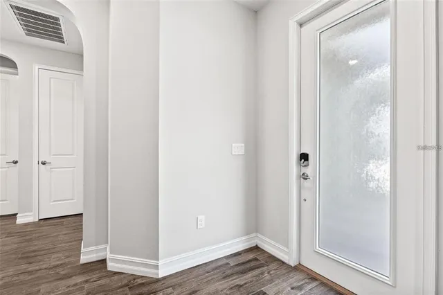 a view of empty room with wooden floor