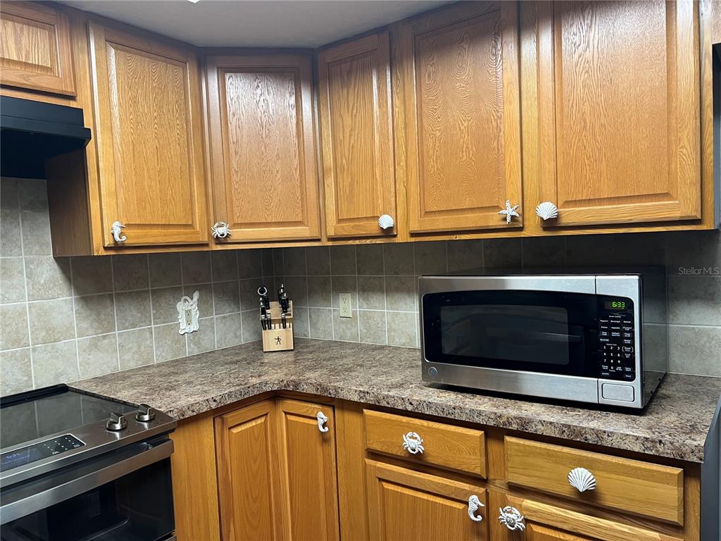 11375 Corrigan Street Spring Hill, FL 34609 - Photo 12 of 36 a kitchen with granite countertop cabinets stainless steel appliances and a window