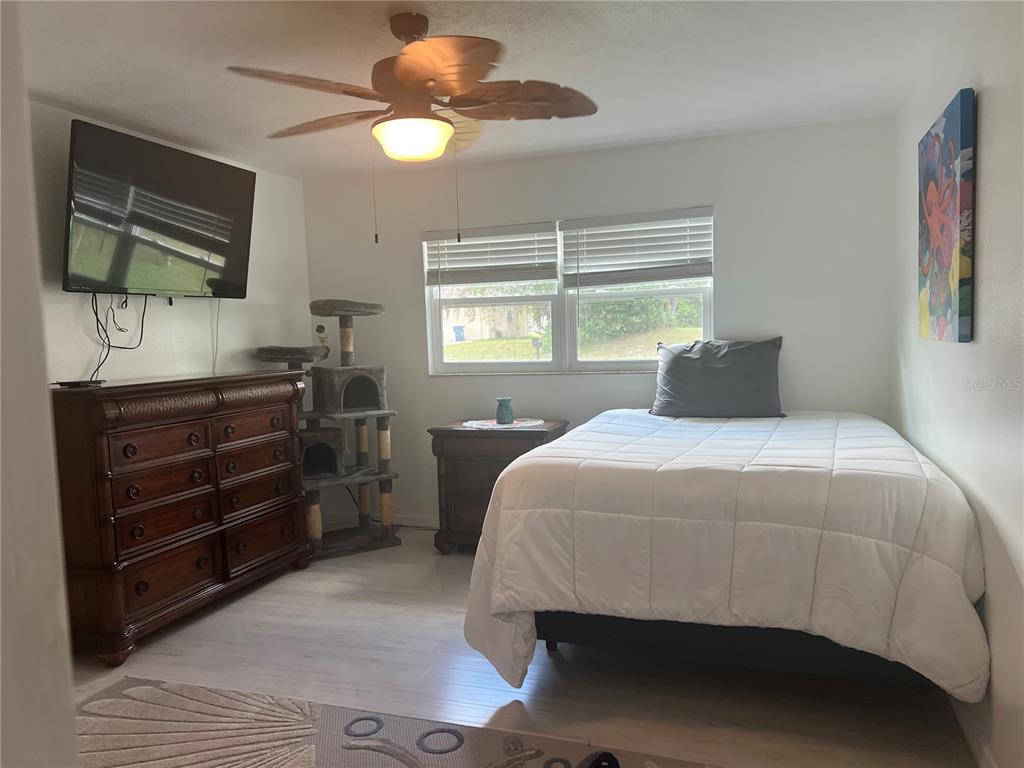 11375 Corrigan Street Spring Hill, FL 34609 - Photo 15 of 36 a bedroom with a bed and a flat tv screen on dresser