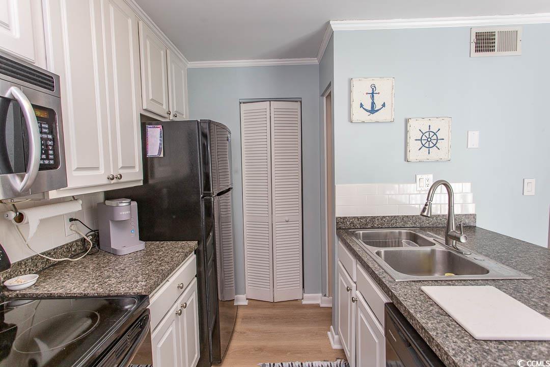 4115 Little River Road, Unit 4F Myrtle Beach, SC 29577 - Photo 7 of 38 Kitchen featuring black appliances, a sink, visibl