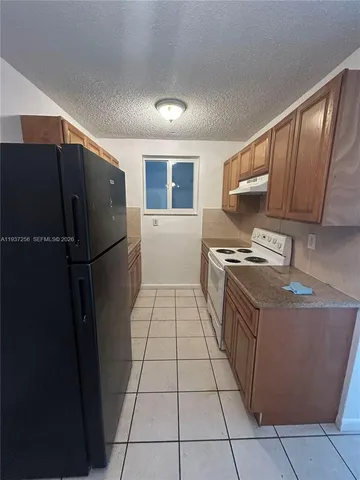 a kitchen with stainless steel appliances granite countertop a refrigerator a stove and a sink