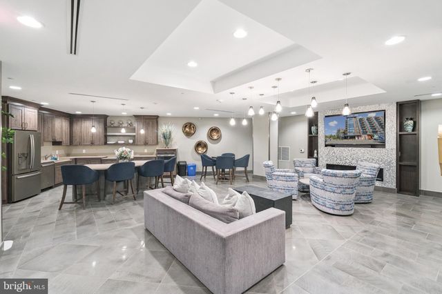 a living room with lots of furniture and kitchen view