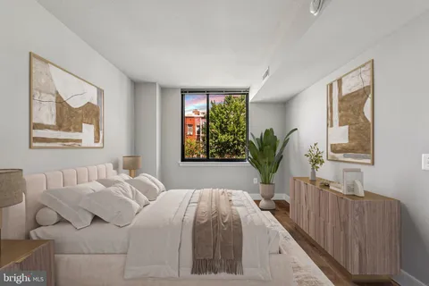a bedroom with a large bed and a potted plant