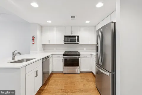 a kitchen with stainless steel appliances granite countertop a refrigerator sink and microwave