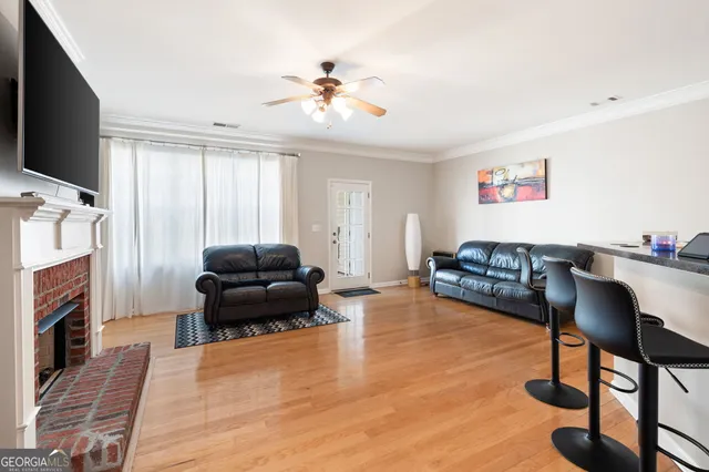 a living room with furniture and a view of kitchen