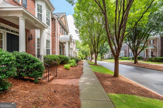 a front view of a house with a yard and trees