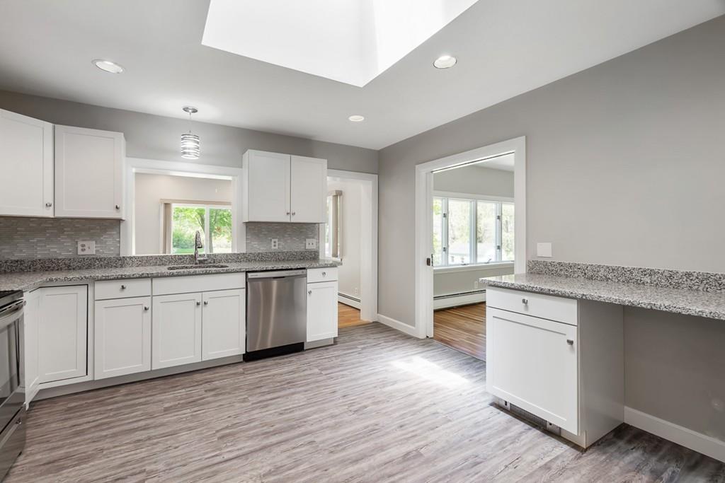 115 Mill Street Lincoln, MA 01773 - Photo 5 of 16 a kitchen with granite countertop white cabinets and white appliances