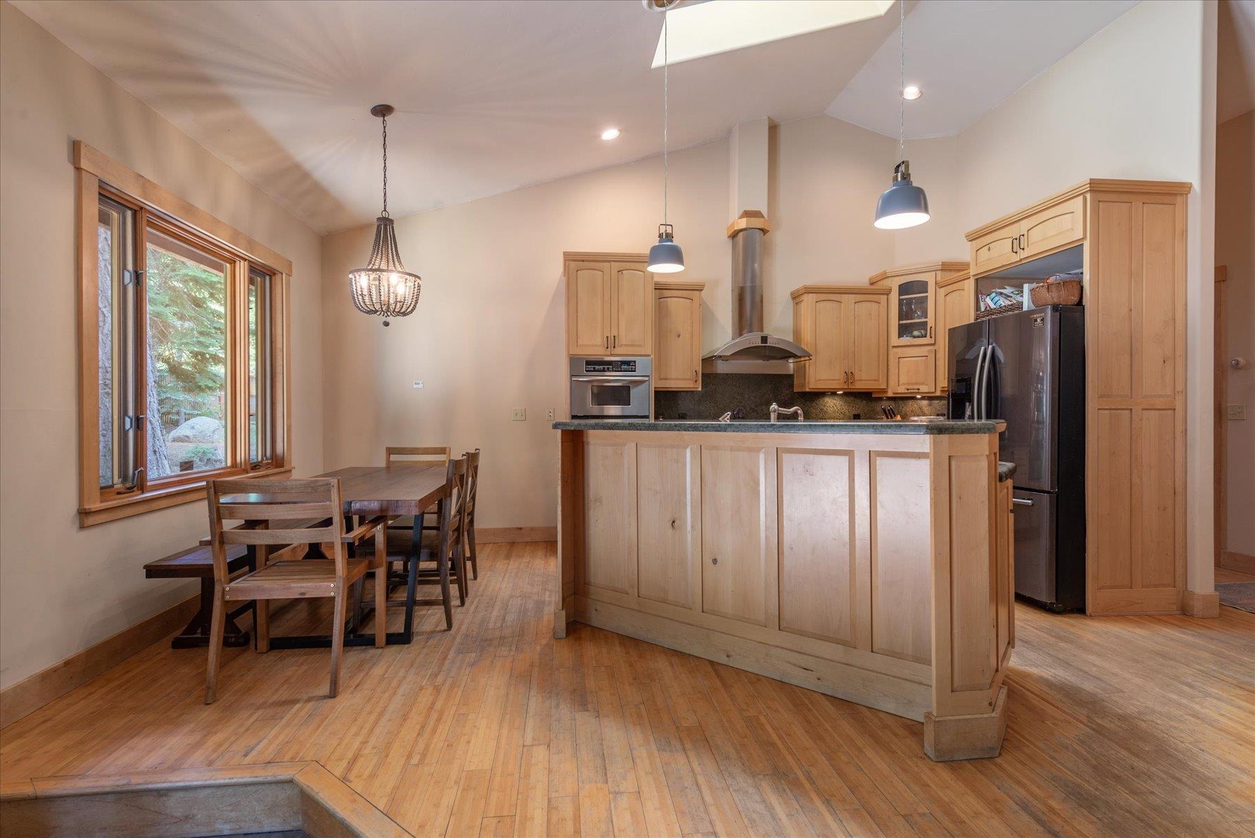 11013 Beacon Road Truckee, CA 96161 - Photo 11 of 20 a kitchen with stainless steel appliances kitchen island granite countertop a table chairs and a refrigerator