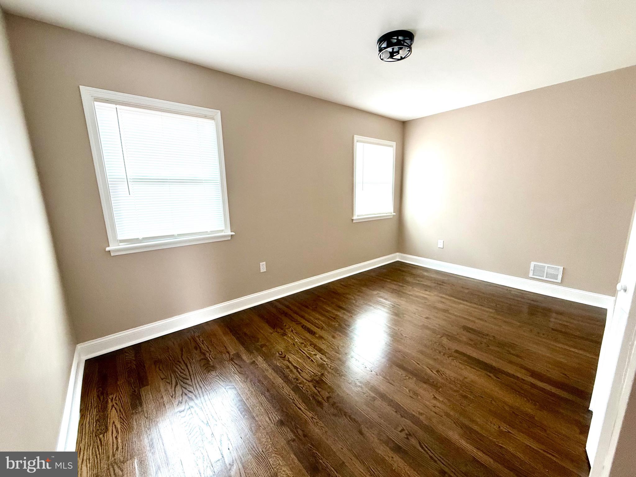 8103 Gray Haven Road Baltimore, MD 21222 - Photo 4 of 14 an empty room with wooden floor and windows