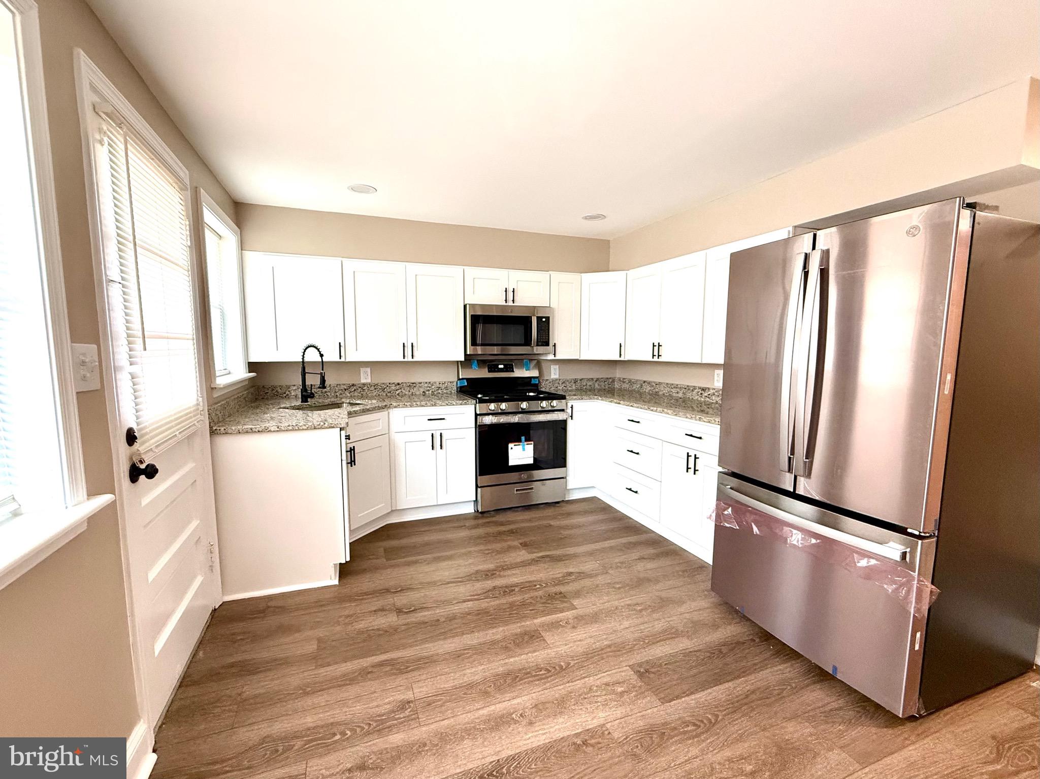 8103 Gray Haven Road Baltimore, MD 21222 - Photo 7 of 14 a kitchen with granite countertop a refrigerator stove top oven and sink