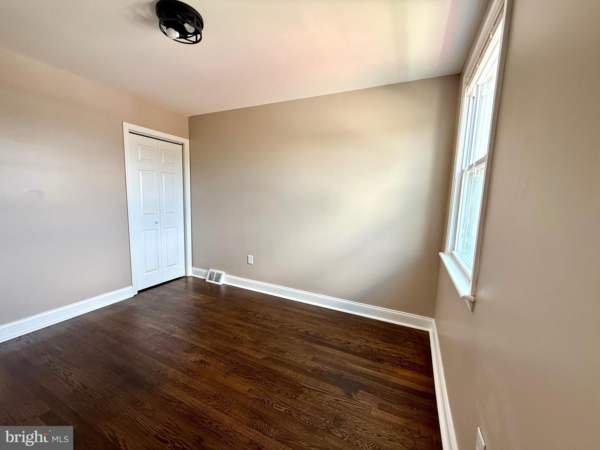 8103 Gray Haven Road Baltimore, MD 21222 - Photo 10 of 14 an empty room with wooden floor and windows