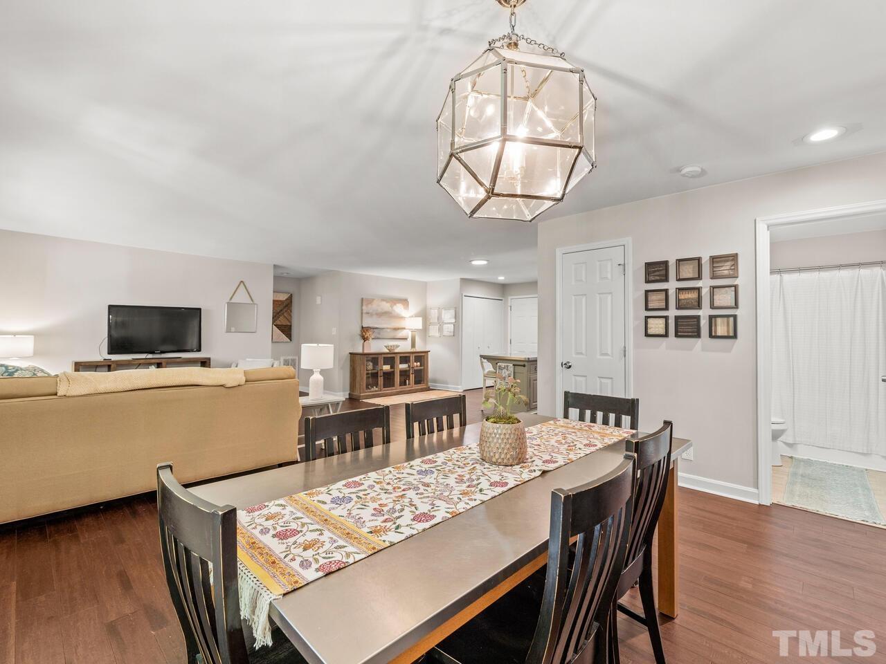 430 Obie Drive Durham, NC 27713 - Photo 13 of 35 a dining room with wooden floor a chandelier a wooden table and chairs