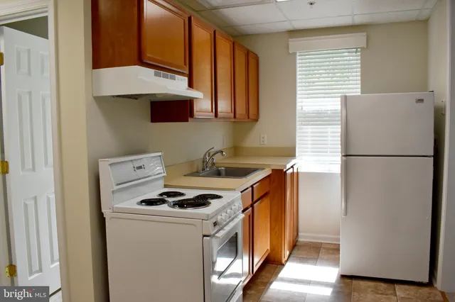 a kitchen with sink a refrigerator and a stove