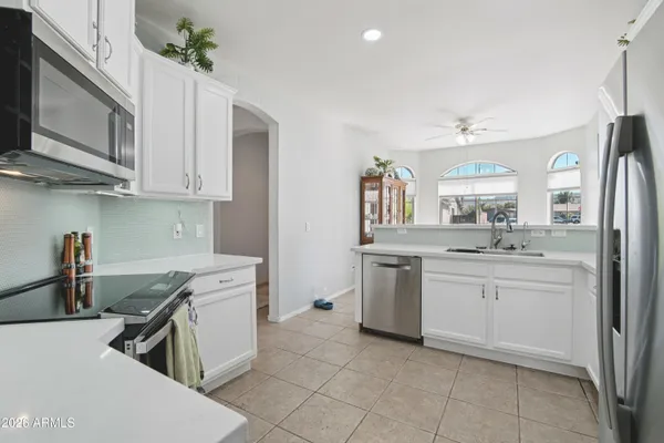a kitchen with granite countertop a refrigerator stove top oven and sink