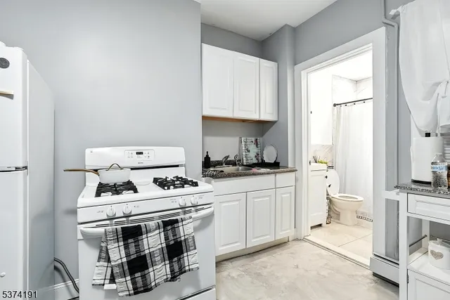 a kitchen with a stove and white cabinets