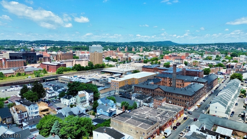 50 Oak Street Paterson, NJ 07501 - Photo 3 of 28 an aerial view of a city with lots of residential buildings ocean and mountain view in back
