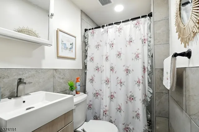 a bathroom with a sink a toilet and shower curtain